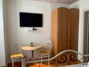 a room with a table and a tv on the wall at Goga in Selce