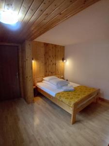 a bedroom with a large bed with wooden walls at Casuta Azughia in Azuga