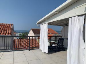 a patio with white curtains on a balcony at Goga in Selce