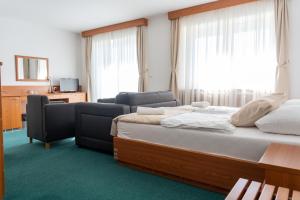 ein Hotelzimmer mit einem Bett und zwei Stühlen in der Unterkunft Hotel Tisa Pohorje in Hočko Pohorje