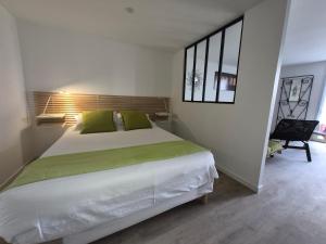 a bedroom with a large white bed and a window at Chez Helje in Les Essards-Taignevaux