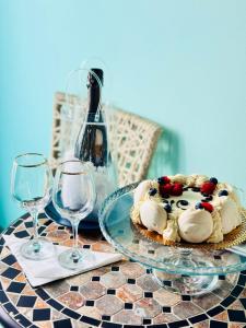 a table with a cake and two wine glasses at La Polena Camere Vernazza - Suite vista mare in Vernazza