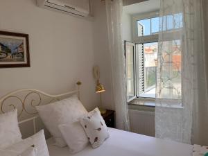 a bedroom with a white bed and a window at Goga in Selce