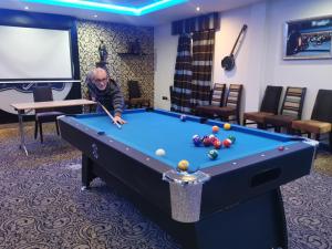 a man playing pool in a billiard room at The BlueBell Hotel in Neath