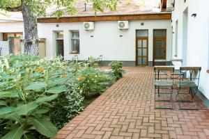a patio with benches and flowers in front of a house at Csaba Vendégház in Izsák
