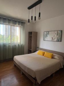 a bedroom with a large bed with two yellow pillows at Olympic Lodge in Milan