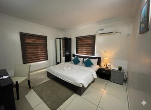 a bedroom with a bed and a desk and a chair at TRENDY INN LTD in Lagos +10 photos