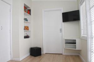 sala de estar con puerta y TV en Smugglers Inn Studio Apartments en Victor Harbor