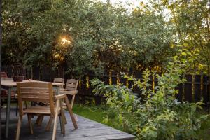a wooden table and chairs in a garden at Lawendowe Pole - Domek Różany in Nowe Kawkowo