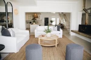 a living room with two white couches and a table at White Wicker House in Langebaan