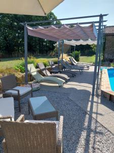 a group of chairs and an umbrella next to a pool at Beautiful 2 bed cottage with swimming pool in Pagéas