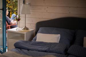 a bedroom with a bed with a pillow and a lamp at Lawendowe Pole - Domek Różany in Nowe Kawkowo