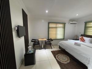 a bedroom with a bed and a table with chairs at TRENDY INN LTD in Lagos