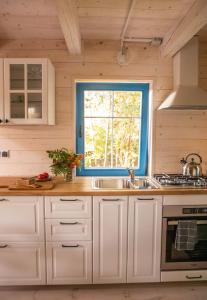a kitchen with a sink and a window at Lawendowe Pole - Domek Różany in Nowe Kawkowo