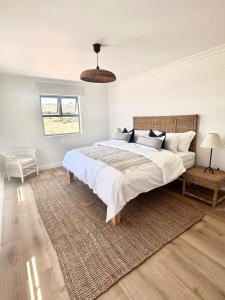 a bedroom with a large bed and a couch at White Wicker House in Langebaan
