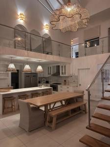 a large kitchen with a wooden table and a chandelier at White Wicker House in Langebaan