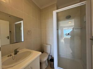 a bathroom with a sink and a toilet and a shower at Boardwalk 11 in Struisbaai