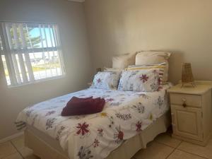 a bedroom with a bed with a flowery comforter at Boardwalk 11 in Struisbaai