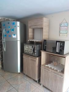 a kitchen with a refrigerator and a microwave at Recanto Romig in Pomerode