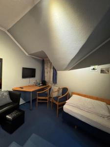 a hotel room with a bed and a desk and a table at Nassauer Hof Wiesbaden-Schierstein in Wiesbaden