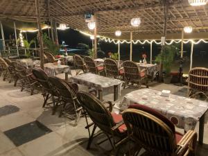 a dining area with tables and chairs and lights at Mountain Palm patnem beach in Patnem