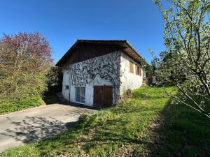 a small stone building with a door on a road at Chambre-Studio et SAUNA indépendants in Annecy