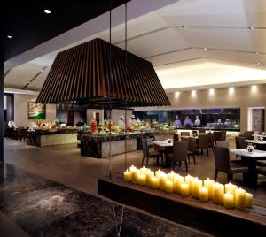 a restaurant with tables and a large chandelier at Mission Hills Resort Haikou in Haikou