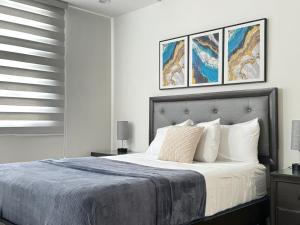a bedroom with a bed with two pictures on the wall at Parkhurst Lux Condo Near Devon House in Kingston