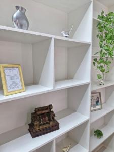 a white book shelf with a box on it at Flat Casa Grande in Itapira