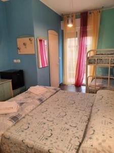 a bedroom with two beds and a tv and two windows at Hotel Mirage in Rimini