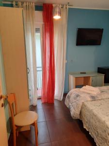 a bedroom with a bed and a chair and a window at Hotel Mirage in Rimini +4 photos
