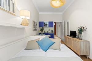 a living room with a bed and a television at Bright City Hideaway, Augarten and Danube - 5 min Metro - 10 min Center in Vienna