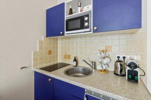 a kitchen with a sink and a microwave at Bright City Hideaway, Augarten and Danube - 5 min Metro - 10 min Center in Vienna +80 photos