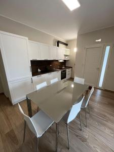 a kitchen with a dining table and white cabinets at Antico Pozzo in Badia +16 photos
