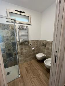 a bathroom with a toilet and a glass shower at Antico Pozzo in Badia