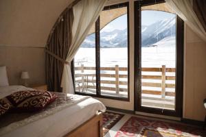 a bedroom with a bed and a view of a mountain at Мурас Эко - Ресорт in Alamedin