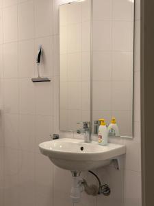 a white bathroom with a sink and a mirror at Davik Fjordparadis in Bakken