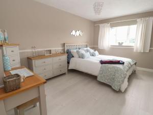 a bedroom with a bed and a desk and a window at Castle View in Deganwy
