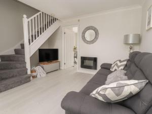 a living room with a couch and a staircase at Castle View in Deganwy