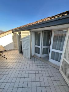 a house with doors and a tiled patio at il canto del lago in Iseo