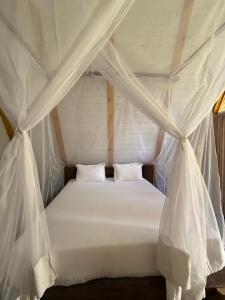 a bedroom with a bed with mosquito netting at Luma in Palolem