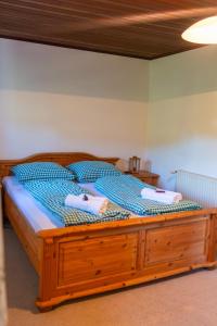 a large wooden bed with two towels on it at Winzerhaus Löscherannerl in Kogl