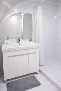 a white bathroom with a sink and a mirror at Мурас Эко - Ресорт in Alamedin +71 photos