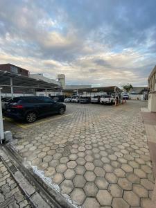 a parking lot with cars parked in front of a building at Prisma Plaza Hotel in Taubaté