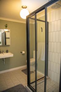 a bathroom with a shower and a toilet and a sink at Beachside Modern Holiday Apartments in Cape Town +24 photos