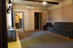 a living room with a couch and a brick wall at Csaba Vendégház in Izsák