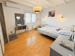 a bedroom with a bed and a desk in it at Maison 4 ch, véranda, proche commodités, Aurillac in Aurillac