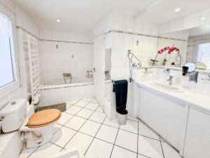 a white bathroom with a toilet and a sink at Maison 4 ch, véranda, proche commodités, Aurillac in Aurillac +15 photos