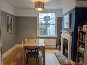 a dining room with a table and a fireplace at Seaside 4 bed terraced house in Hastings +12 photos