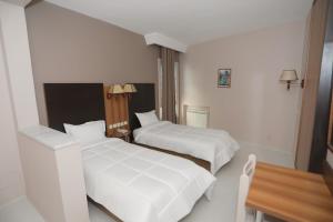 a hotel room with two beds and a table at Hotel karim Tunis in Tunis